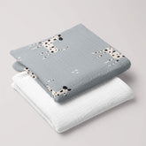 Folded Dalmatian muslin swaddle and soft white 4-ply baby blanket